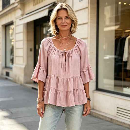 Elegancka damska bluzka z falbanami i wiązaniem przy dekolcie, rękawami 3/4 typu dzwon, o fakturowanym materiale i w stylu boho-chic, w swobodnym fasonie z baskinką.